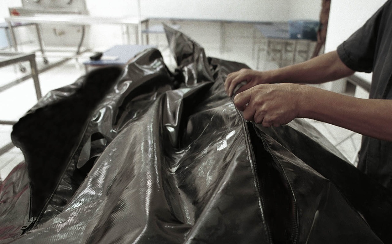 Perito abre una bolsa en la que se resguarda un cuerpo dentro de un Semefo. Crédito: Rafael del Río